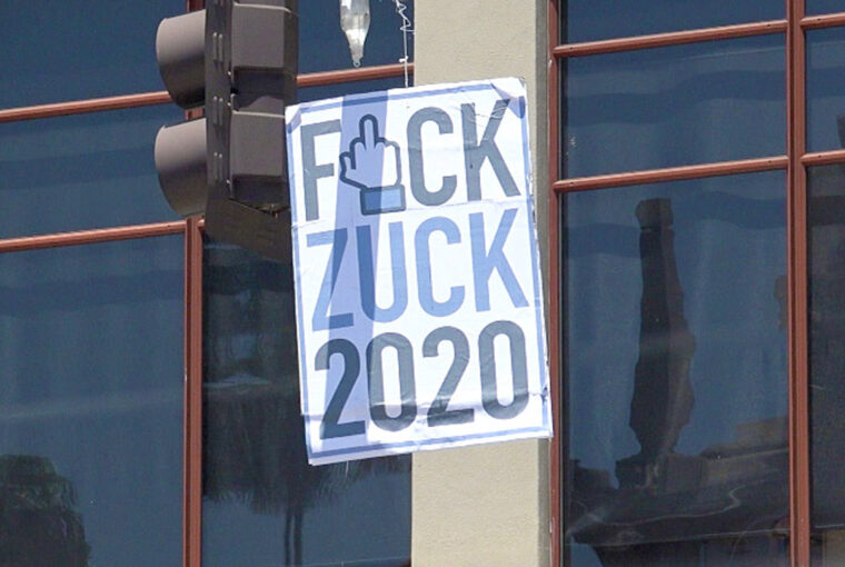 A sign hanging from the side of a building.