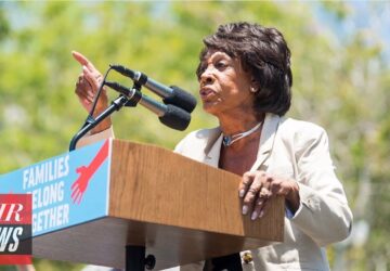 A woman is speaking at a podium with microphones.