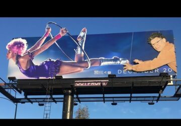 A billboard with two people on it and one of them is holding a hula hoop.