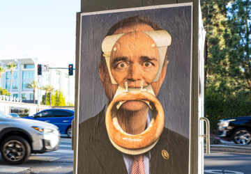 A poster of president obama with a bagel in his mouth.