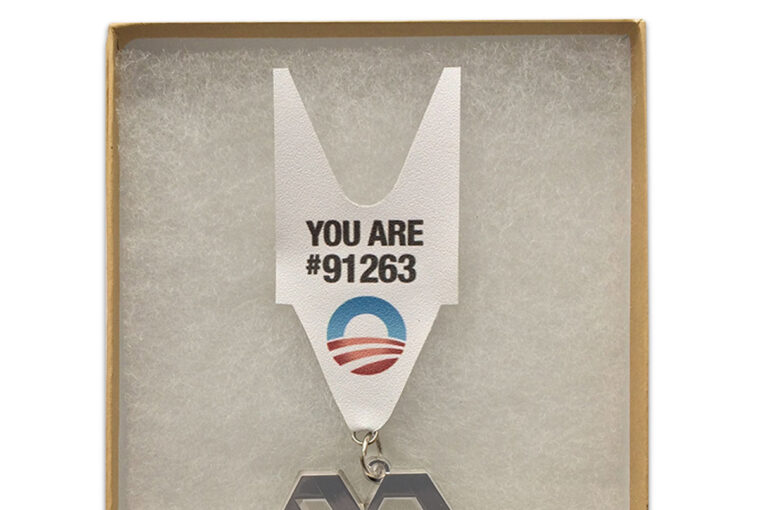 A medal with the obama logo and the hashtag " you are # 9 1 2 6 3 ".
