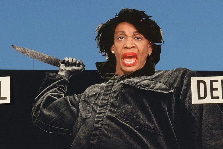 A man holding a knife in front of his face.