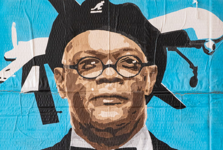 A painting of a man wearing glasses and a hat.