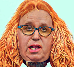 A woman with red hair and glasses is looking at the camera.