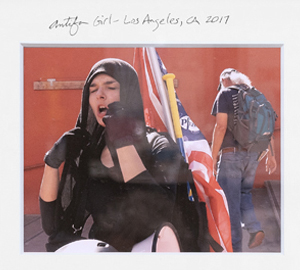 A woman with her hands on her face and holding an american flag.